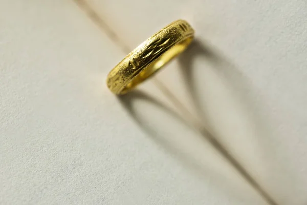 Bague en or avec forme de coeur d'ombre sur la page du livre — Photo