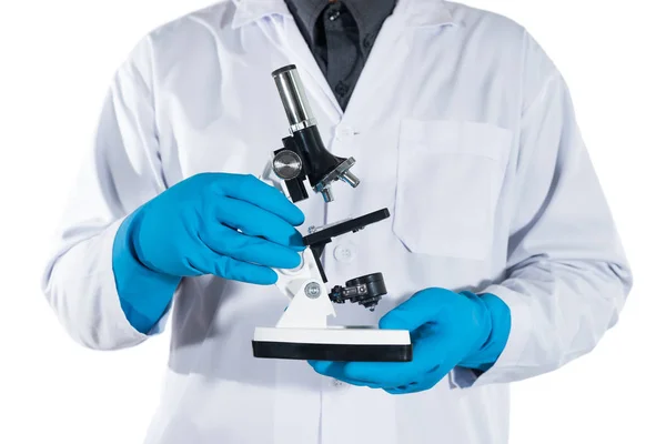 Ученый держит микроскоп в руке на белом фоне — стоковое фото