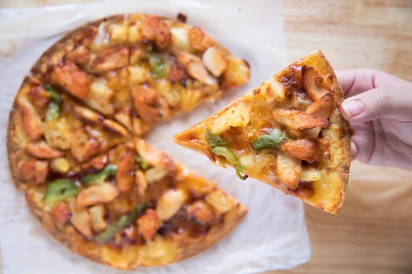 Mão pegar um pedaço de churrasco frango suprema pizza — Fotografia de Stock