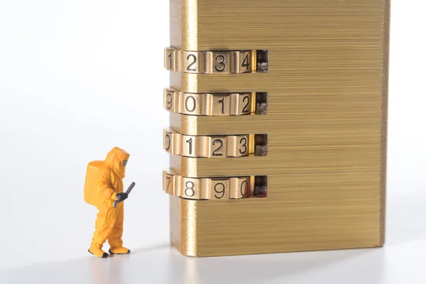 Miniatuur mensen probeert te ontgrendelen metalen veiligheid lock-toets — Stockfoto