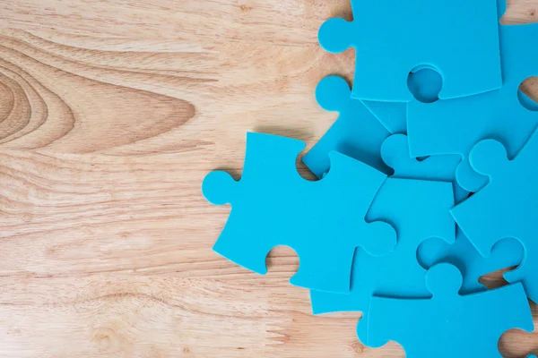 Blue jigsaw puzzle pieces on wooden background — Stock Photo, Image