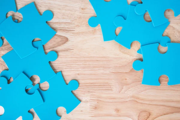 Puzzle bleu pièces sur fond en bois — Photo