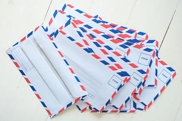 Envelope de correio aéreo no fundo de madeira branco — Fotografia de Stock