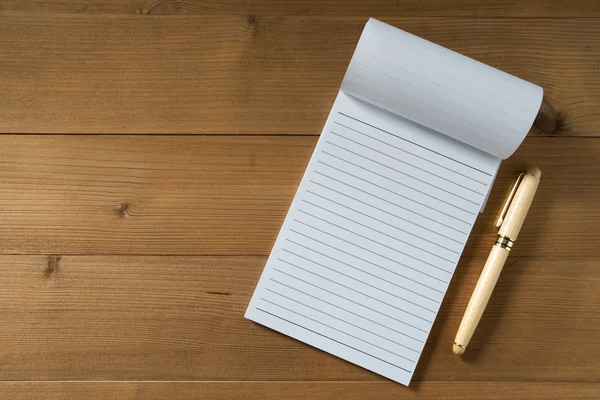 Cuaderno en blanco con pluma sobre mesa de madera marrón — Foto de Stock