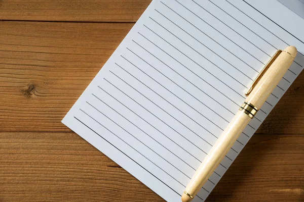 Cuaderno en blanco con pluma sobre mesa de madera marrón — Foto de Stock