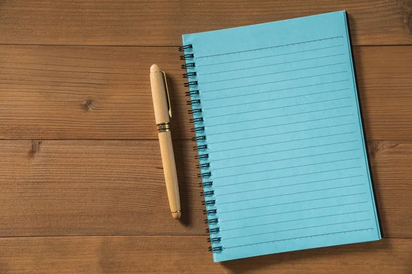 Tom anteckningsbok med penna på brunt trä bord — Stockfoto