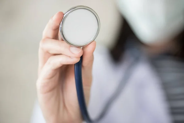 Konfidentiella kvinna läkare med gröna stetoskop i hand — Stockfoto
