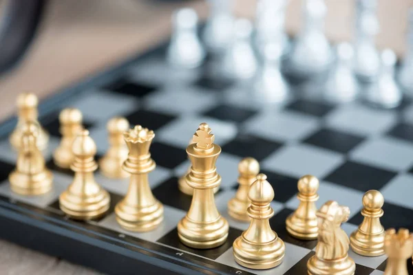 Золоті шахові фігури на шахівниці — стокове фото