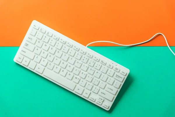 White computer keyboard on orange green background — Stock Photo, Image