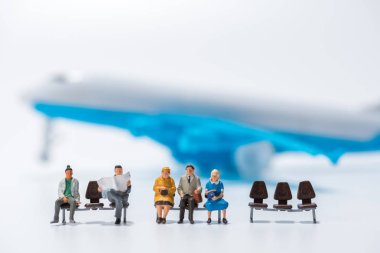 satır hava uçak m ile bankta oturmuş minyatür insan figürü