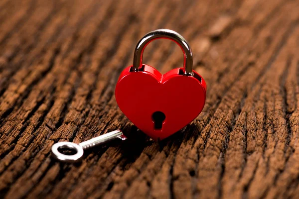 Cerradura roja de la llave del corazón sobre fondo de madera —  Fotos de Stock