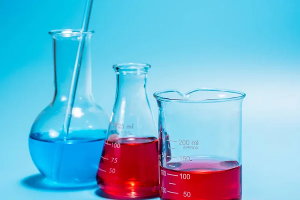 Tabung percobaan laboratorium sains pada latar belakang biru muda, ilmu pengetahuan e — Stok Foto
