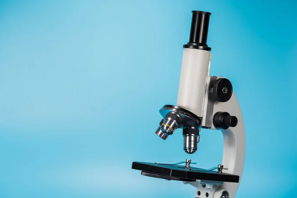 Microscópio de ciência em fundo azul claro — Fotografia de Stock