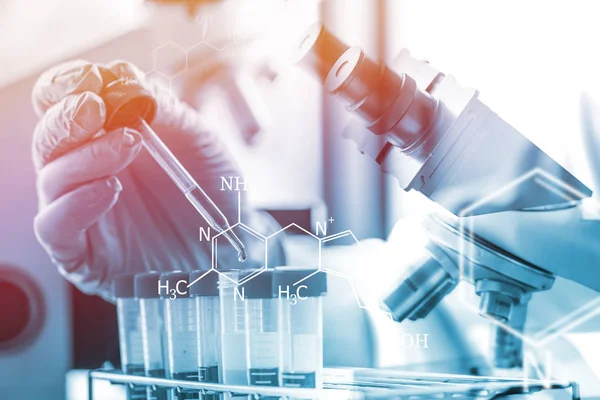 Scientist or doctor dropping a blood into blood test tube — Stock Photo, Image