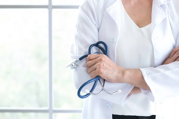 Konfidentiella kvinna läkare med blå stetoskop i hand — Stockfoto