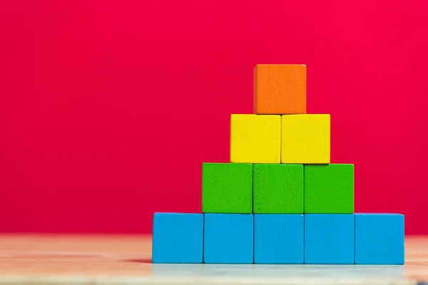 Pilha de blocos de construção de cubo de madeira no fundo vermelho — Fotografia de Stock