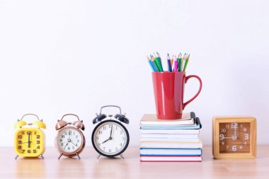 kalem kutusu kitap yığını ve çalar saat ahşap tablo