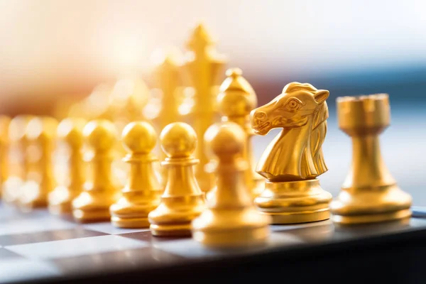 Gold chess pieces on a chessboard, business strategy concept — Stock Photo, Image