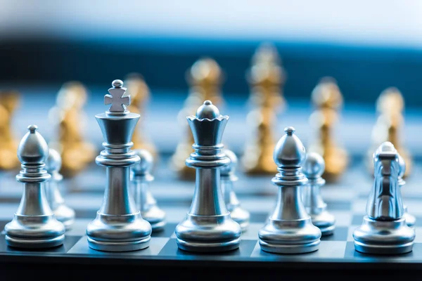 Срібні шахові фігури на срібній шахівниці, ділова стратегія — стокове фото