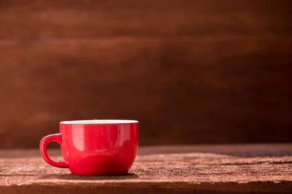 Röd kaffekopp på träbord — Stockfoto