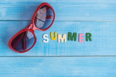 sunglass ve metin yaz ışık mavi ahşap tahta üzerinde yukarıdan 