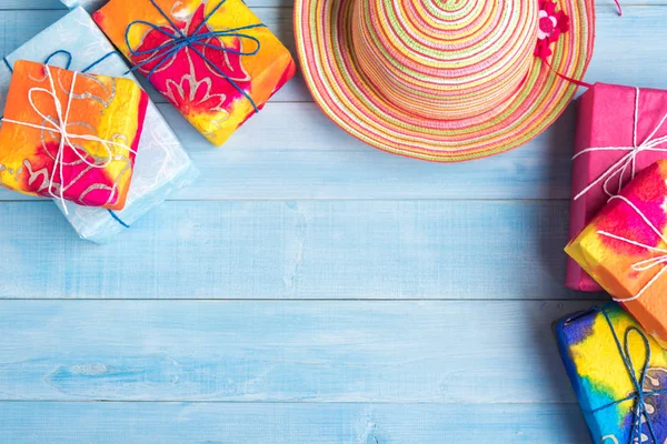 Vista superior del sombrero de paja y caja de regalo en tablón de madera azul claro — Foto de Stock