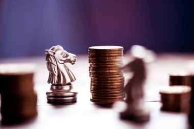 satranç taşları ve sikkeler üzerinde bir satranç tahtası yığını