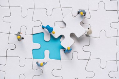 minyatür insanlar takım son parçalı bulmaca tamamlamak çalışıyor 