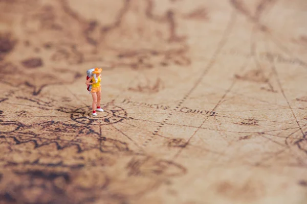 Miniature traveler on vintage world map — Stock Photo, Image