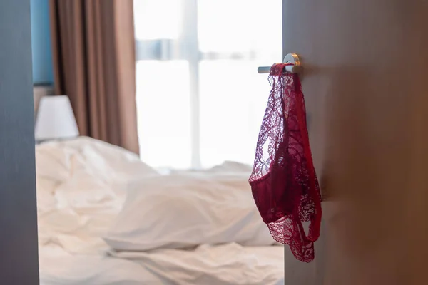 Red woman panties hanging on the door knob — Stock Photo, Image