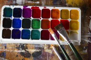 Sulu boya seti ve fırçalar ahşap bir masa üzerinde