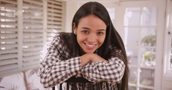 Jolie latina femme assise à la maison souriant à la caméra — Photo