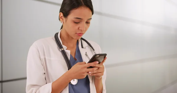 Médico mujer mexicana mensajes de texto en smartphone — Foto de Stock
