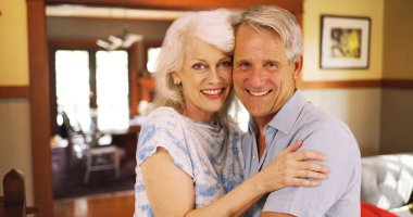 Ev kameraya bakıyor oturan gülümseyen yaşlı çift