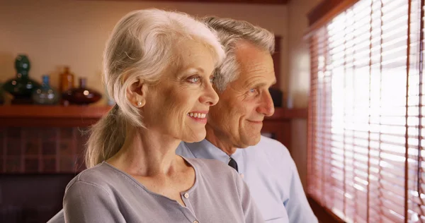 幸福的老夫妇从窗户往外看的特写镜头 — 图库照片