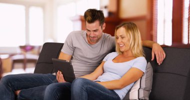 Millennials tablet birlikte evde bir kanepede oturan komik video izleme