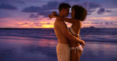 Genç çift birbirlerine okyanus dalgaları seyretmekten kumsalda holding.