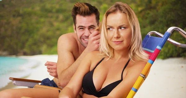 千禧一代夫妇坐在一起在海滩上傻傻的微笑着对着镜头 — 图库照片