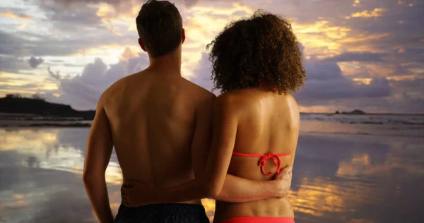 Attractive young couple holding each other on beach.