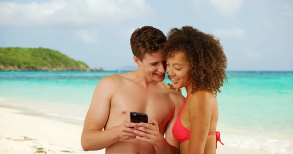 ハンサムな白人男性女性友人のビーチでスマート フォンを使用して — ストック写真