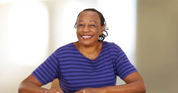 An elderly black woman smiling at the camera