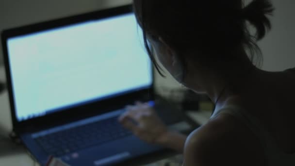 Женщина, работающая на ноутбуке в домашнем интерьере — стоковое видео