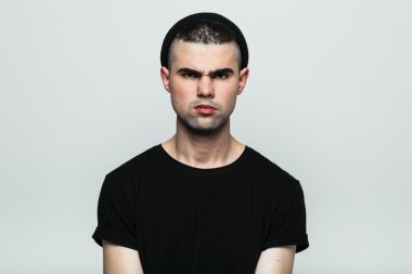 Agresif genç adam kameraya bakıyor