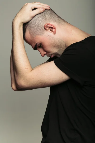 Adam başını iki eliyle siyah t-shirt — Stok fotoğraf
