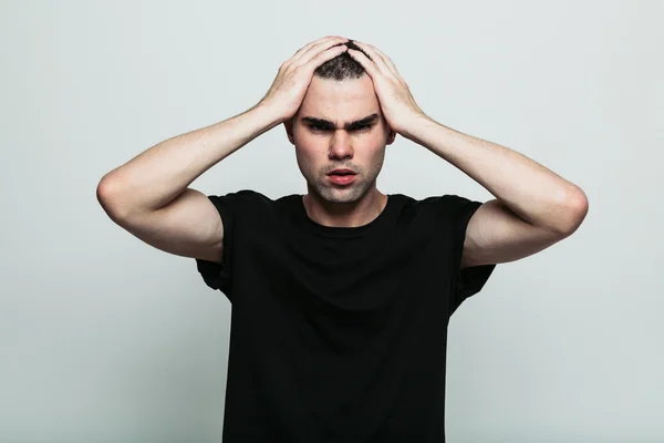 Worrying man posing at studio with arm on head — Stock Photo, Image