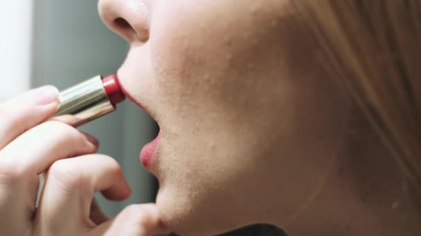 Hermosa mujer rubia pinta sus labios — Vídeo de stock