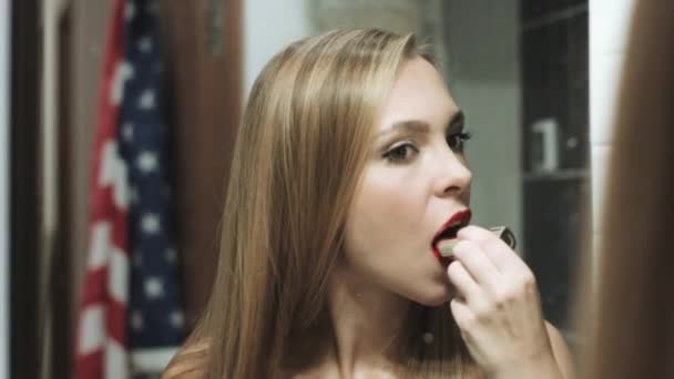 Mooie blonde vrouw schildert haar lippen — Stockvideo