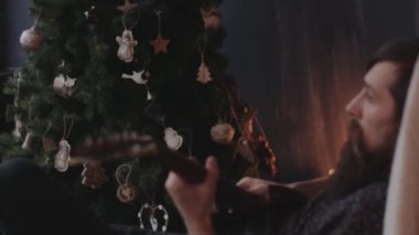 Hipster koltukta oturan elektro gitar çalmak.