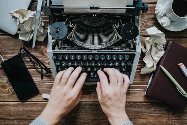 Writer typing with retro writing machine.