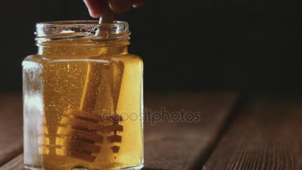 Close up of honey stick in jar — Stock Video